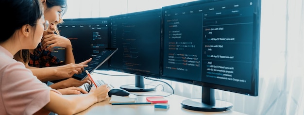 Grupo de desarrolladores web profesionales discuten sobre el análisis de datos mientras la pantalla de la computadora muestra el código de la computadora en la oficina moderna Cerrar Ingeniería digital y concepto de desarrollo web floreciente