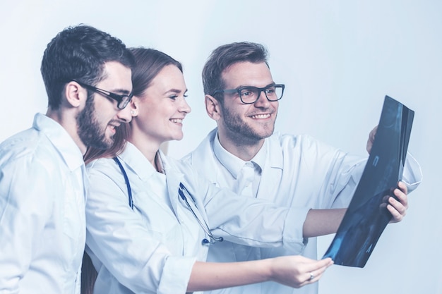 Grupo de diagnosticadores con radiografías sobre un fondo blanco.