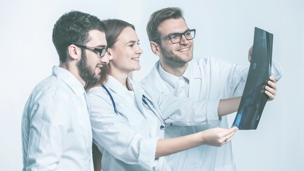 Foto grupo de diagnosticadores con radiografías sobre un fondo blanco.