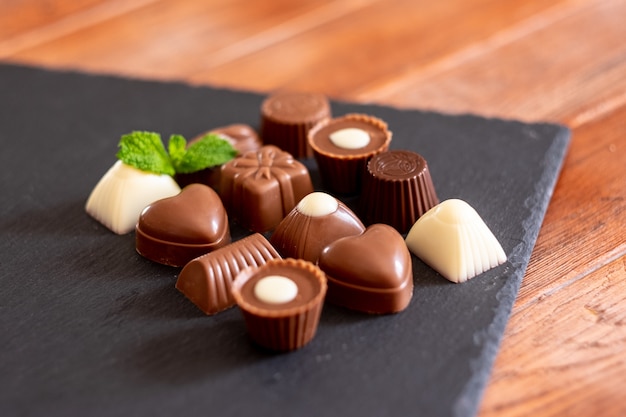 Grupo de diferentes chocolates, con leche y oscuros, sobre un fondo negro.