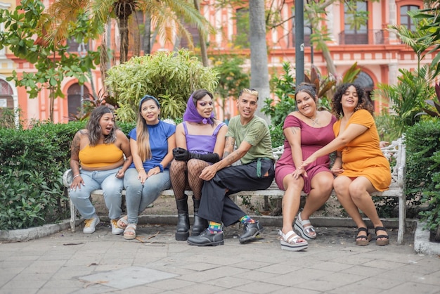 Grupo de diferentes personas sentadas en un banco interactuando entre sí