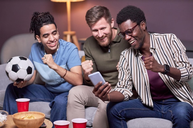 Grupo diversificado de amigos assistindo jogos esportivos online