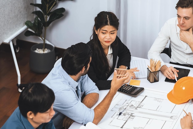 Grupo diversificado de engenheiros civis e clientes trabalhando em arquiteto prudente