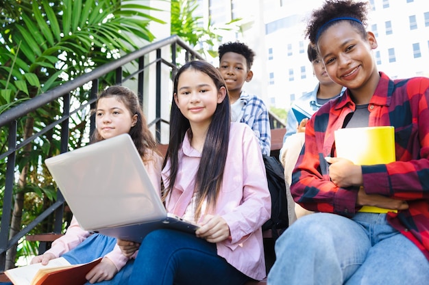 Grupo diversificado de estudantes universitários usando laptops no campus pesquisa popular diversos estudantes universitários