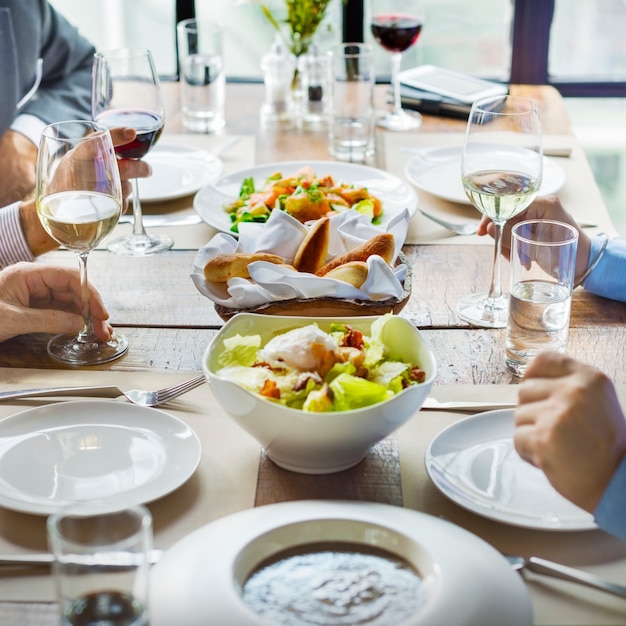 Grupo diverso de adultos cenando, socializando y discutiendo negocios