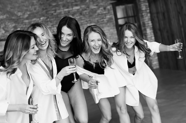 Grupo diverso de amigas disfrutando en una fiesta y riendo. Grupo de hermosas mujeres felices divirtiéndose en ropa blanca