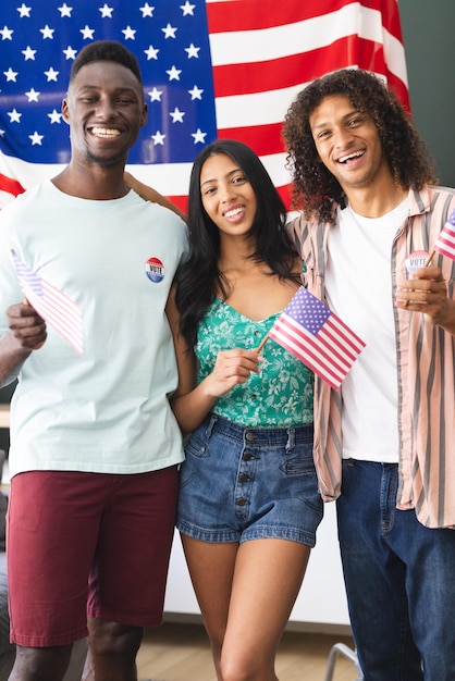 Foto un grupo diverso de amigos de pie ante un fondo de bandera estadounidense