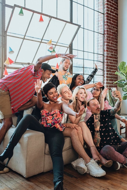 Grupo diverso de amigos tomando un selfie en una fiesta
