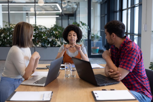 Grupo diverso de empresarios que trabajan en oficinas creativas. grupo de personas en una reunión discutiendo trabajo. gente de negocios y compañeros de trabajo en una oficina creativa ocupada.