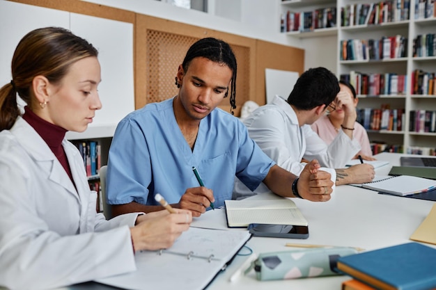 Grupo diverso de médicos y enfermeras jóvenes que trabajan durante una reunión o seminario