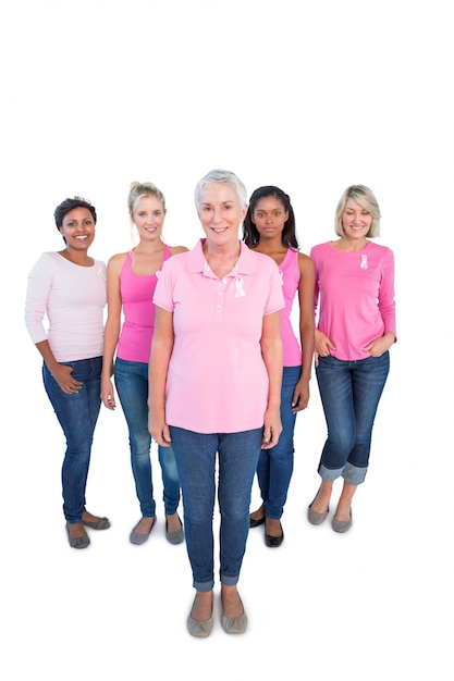 Grupo diverso de mujeres felices con tops rosas y cintas de cáncer de mama