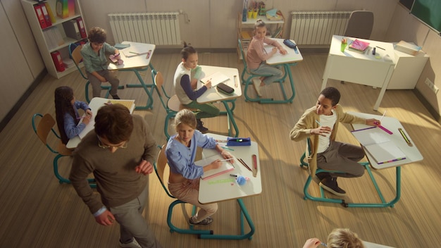 Grupo diverso de niños que tienen una lección en clase con el maestro