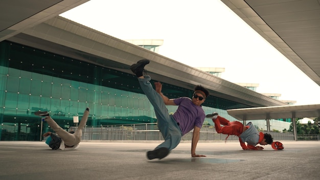 Foto grupo de diversos hipsters o bailarines haciendo giros de cabeza frente al centro comercial con entusiasmo