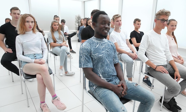 Grupo de diversos jóvenes sentados en una sala de conferencias