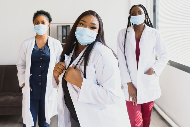 Grupo de doctoras afroamericanas en máscaras protectoras en sus rostros