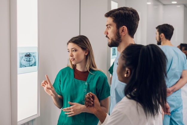 Grupo de doctores que miran la imagen de la radiografía de la mandíbula