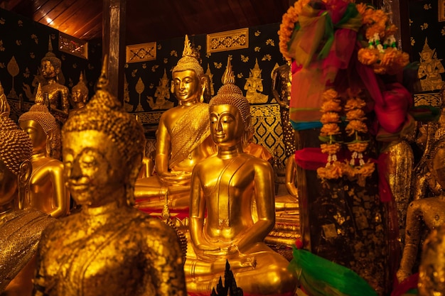 El grupo dorado Buda se enfrenta a la meditación de la estatua sentado con un fondo de Buda dorado arriba y abajo