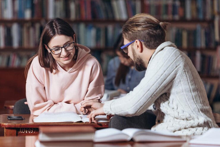 Grupo de dos estudiantes que estudian juntos en la biblioteca pública