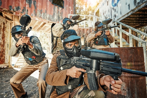 Grupo e equipe do campo de batalha do jogo de paintball em desafio de competição de tiro ou luta ou conflito de armas de missão militar Foco no alvo trabalho em equipe e pessoas em ação ao ar livre de guerra ou treinamento de batalha