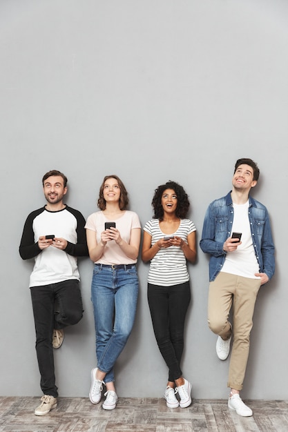 Foto grupo emocional de amigos usando bate-papo de telefones celulares.