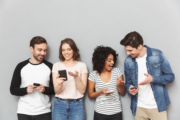 Foto grupo emocional de amigos usando bate-papo de telefones celulares.