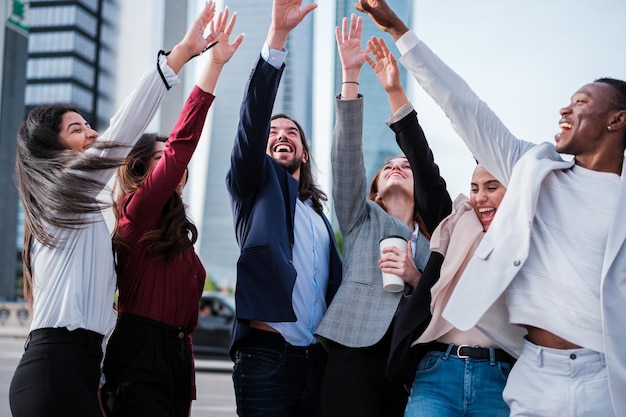 Grupo empresarial celebrando los éxitos de la empresa al aire libre en el distrito financiero