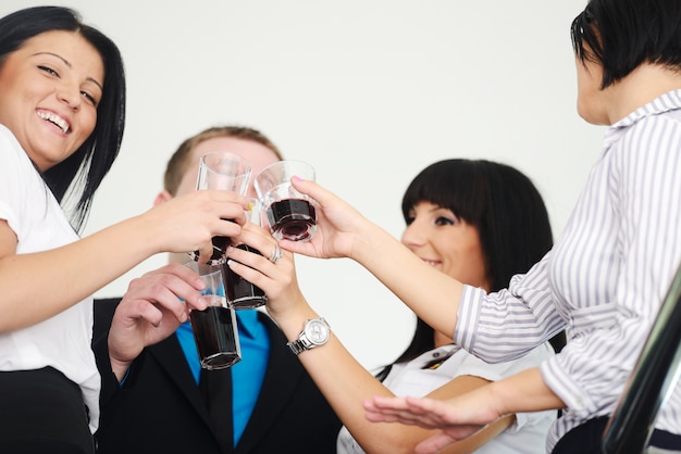 Grupo empresarial celebrando una victoria sosteniendo copas con bebida