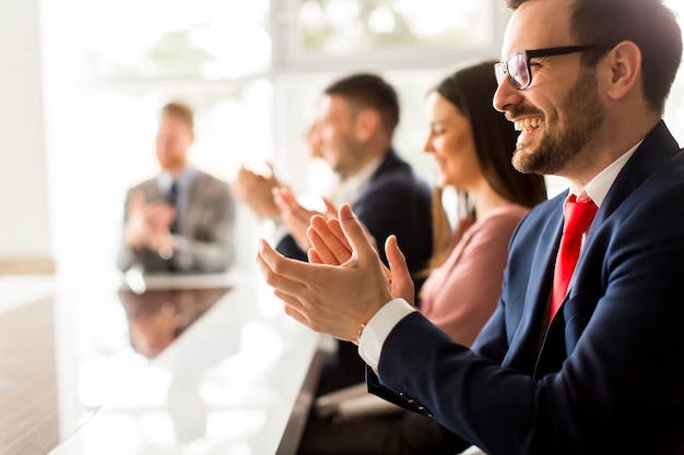 Foto grupo empresarial sonriente aplaudiendo las manos en la reunión