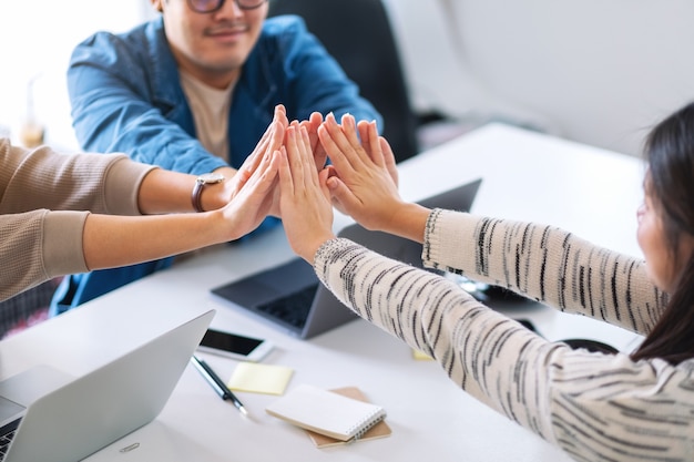 Grupo de empresario juntando sus manos en la reunión