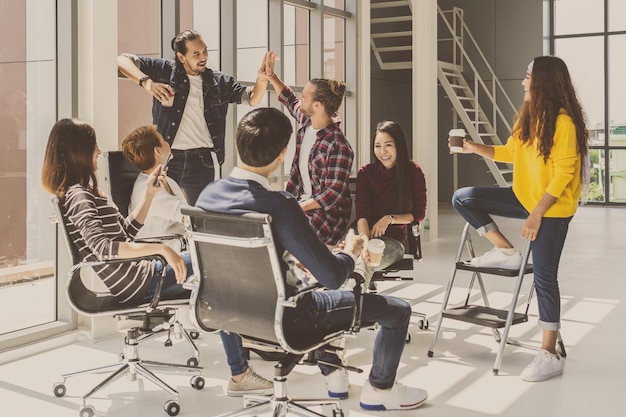 Grupo de empresarios asiáticos y multiétnicos con traje informal hablando y haciendo una lluvia de ideas