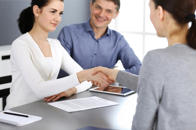 Grupo de empresarios dándose la mano después de discutir preguntas y lograr un acuerdo en una reunión en una oficina moderna. Primer plano de apretón de manos. Trabajo en equipo, asociación y concepto de negocio.