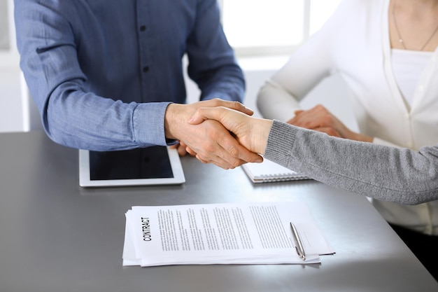 Foto grupo de empresarios dándose la mano después de discutir preguntas y lograr un acuerdo en una reunión en una oficina moderna. primer plano de apretón de manos. trabajo en equipo, asociación y concepto de negocio.