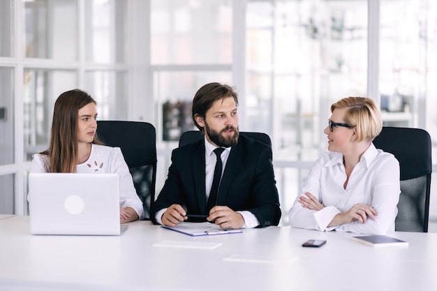 Grupo de empresarios dedicados vestidos con trajes que tienen meeti