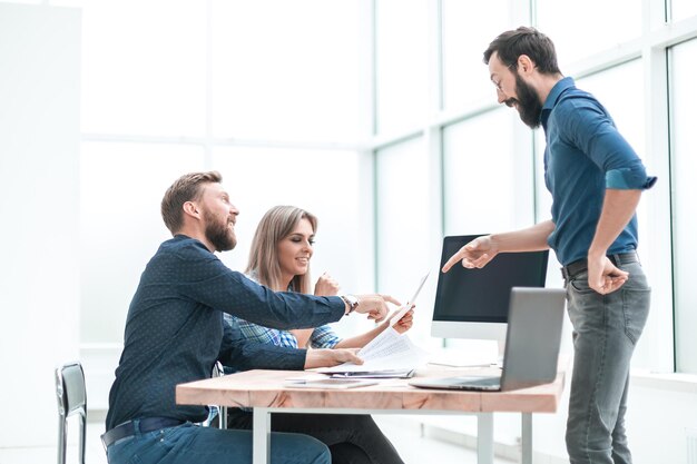 Grupo de empresarios discutiendo algo cerca del escritorio de la oficina