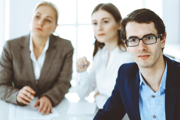 Grupo de empresarios discutiendo preguntas en una reunión en una oficina moderna. Captura de cabeza del empresario en la negociación. Trabajo en equipo, asociación y concepto de negocio.