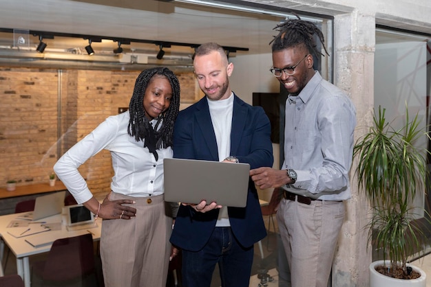 Grupo de empresarios multiétnicos que usan una tableta digital juntos frente a una oficina en un espacio de coworking