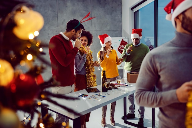 Un grupo de empresarios parados en la oficina y celebrando el Año Nuevo