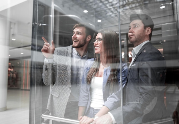 Foto grupo de empresarios de pie en vidrio elevato