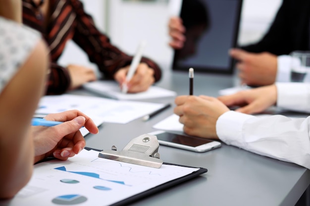 Grupo de empresarios en reunión discutiendo resultados financieros. Mujeres apuntando al monitor de la computadora portátil