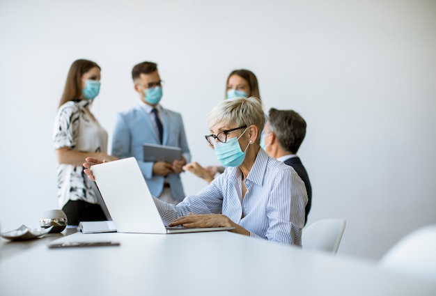 Grupo de empresarios tienen una reunión y trabajan en la oficina y usan máscaras como protección contra el virus corona.