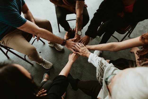 Grupo de equipo diverso que se une de la mano en el medio