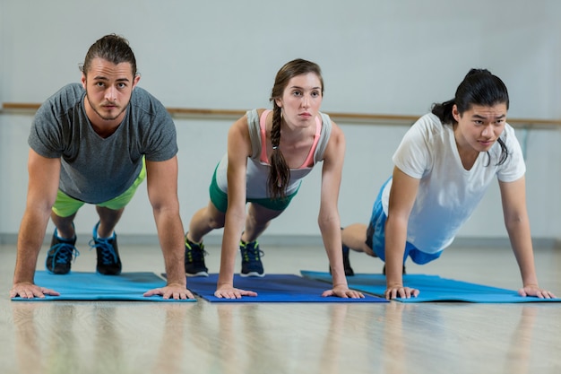 Grupo de equipo de fitness haciendo flexiones