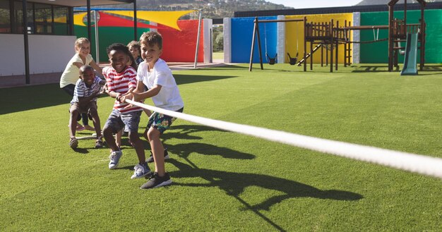 Grupo de escolares jugando tira y afloja