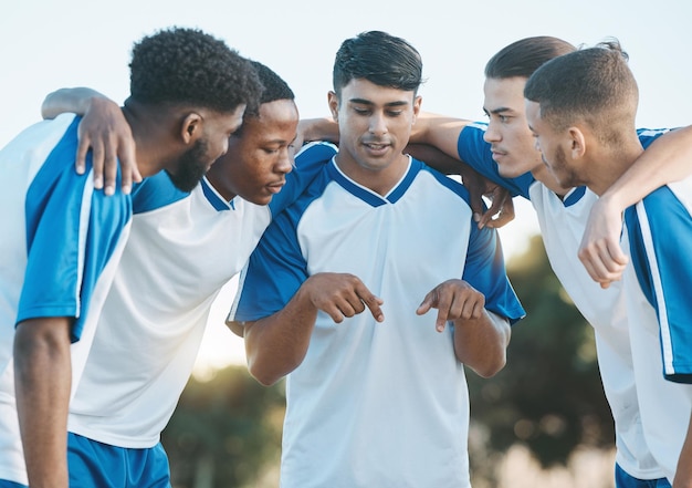 Foto grupo esportivo de futebol e equipe conversando e planejando em campo para treinamento físico ou competição clube de jogadores de futebol e atletas de diversidade juntos para plano de jogo scrum e trabalho em equipe ao ar livre