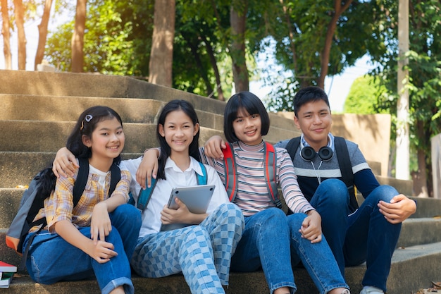 Grupo estudante jovens e livro de leitura de educação no parque da cidade