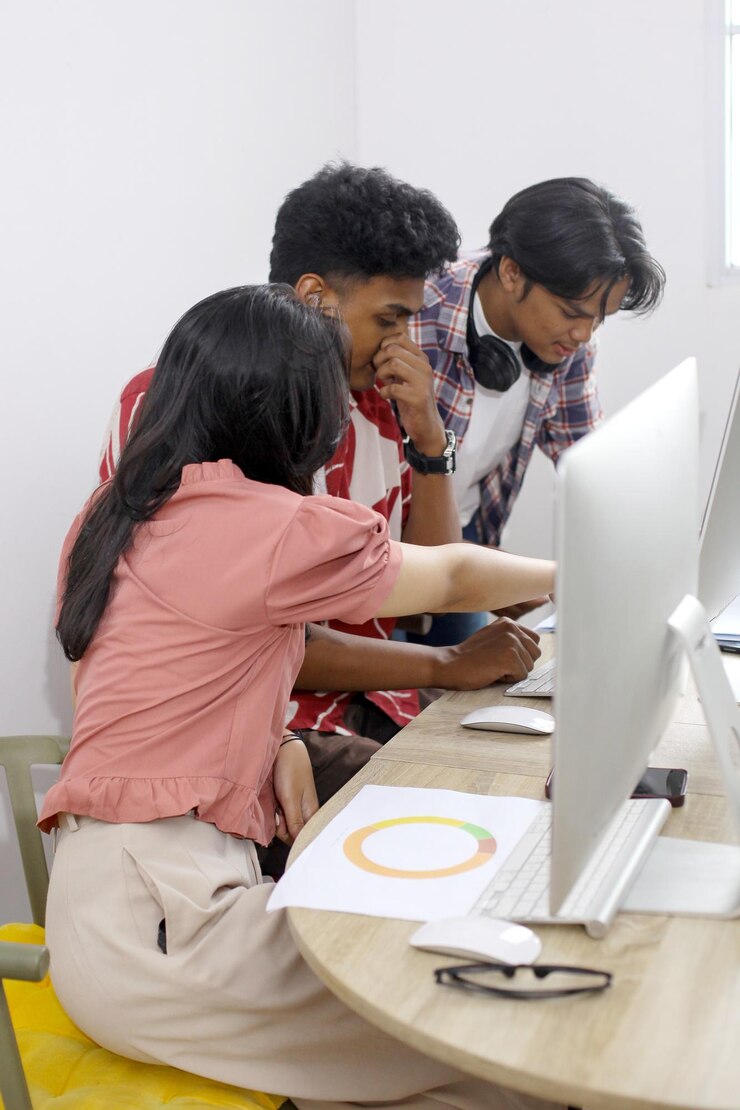 Foto grupo de estudiantes asiáticos trabajando juntos en clase de computadora