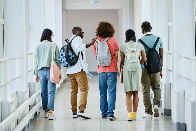 Grupo de estudiantes caminando por el pasillo de la escuela