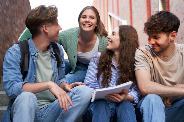 Grupo de estudiantes caucásicos que estudian fuera del campus universitario