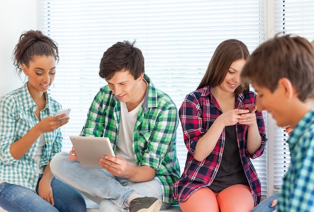 Grupo de estudiantes con dispositivos sobre fondo