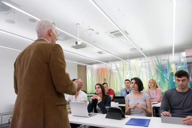 grupo de estudiantes estudian con el profesor en el aula de la escuela moderna